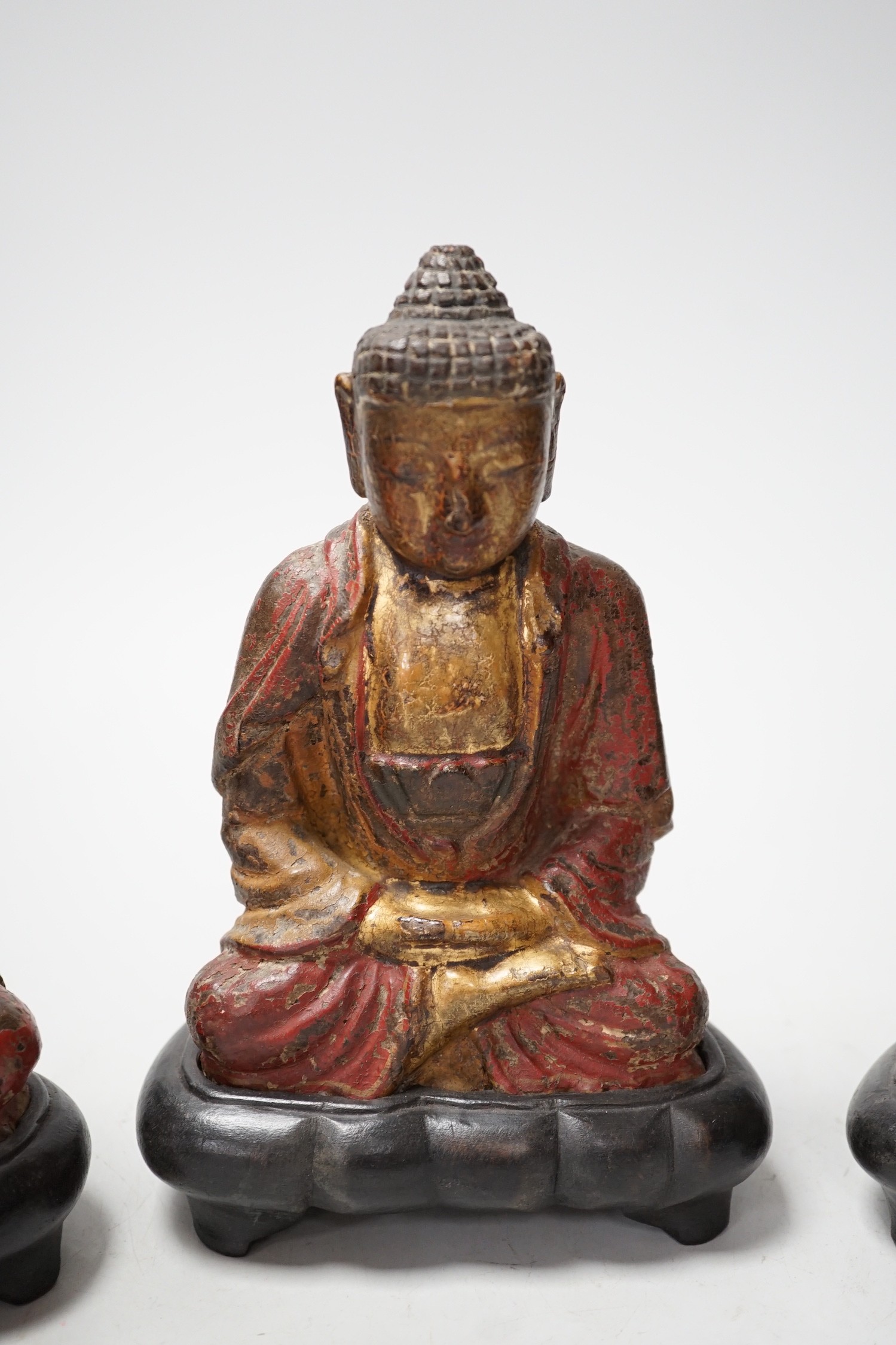A set of three Chinese polychrome lacquered wood seated figures of Buddha, 19cm